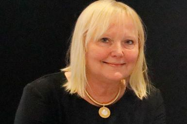 Professor Ann Nordgren från Karolinska-UDP i Sverige ler mot kameran, med axellångt blont hår och ett guldhalsband med hänge.