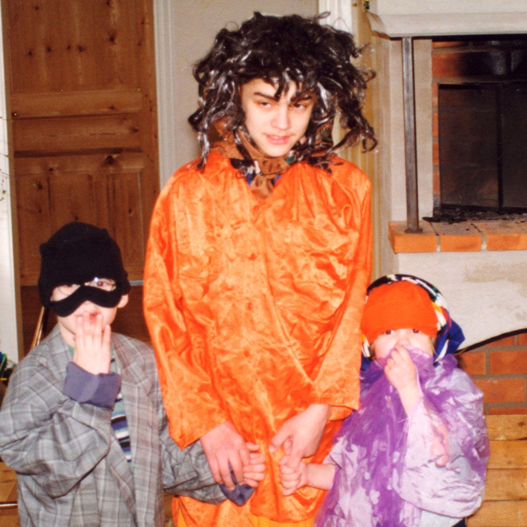 Wilhelm, Hugo and Emma as young children, dressed up in colorful costumes at home.