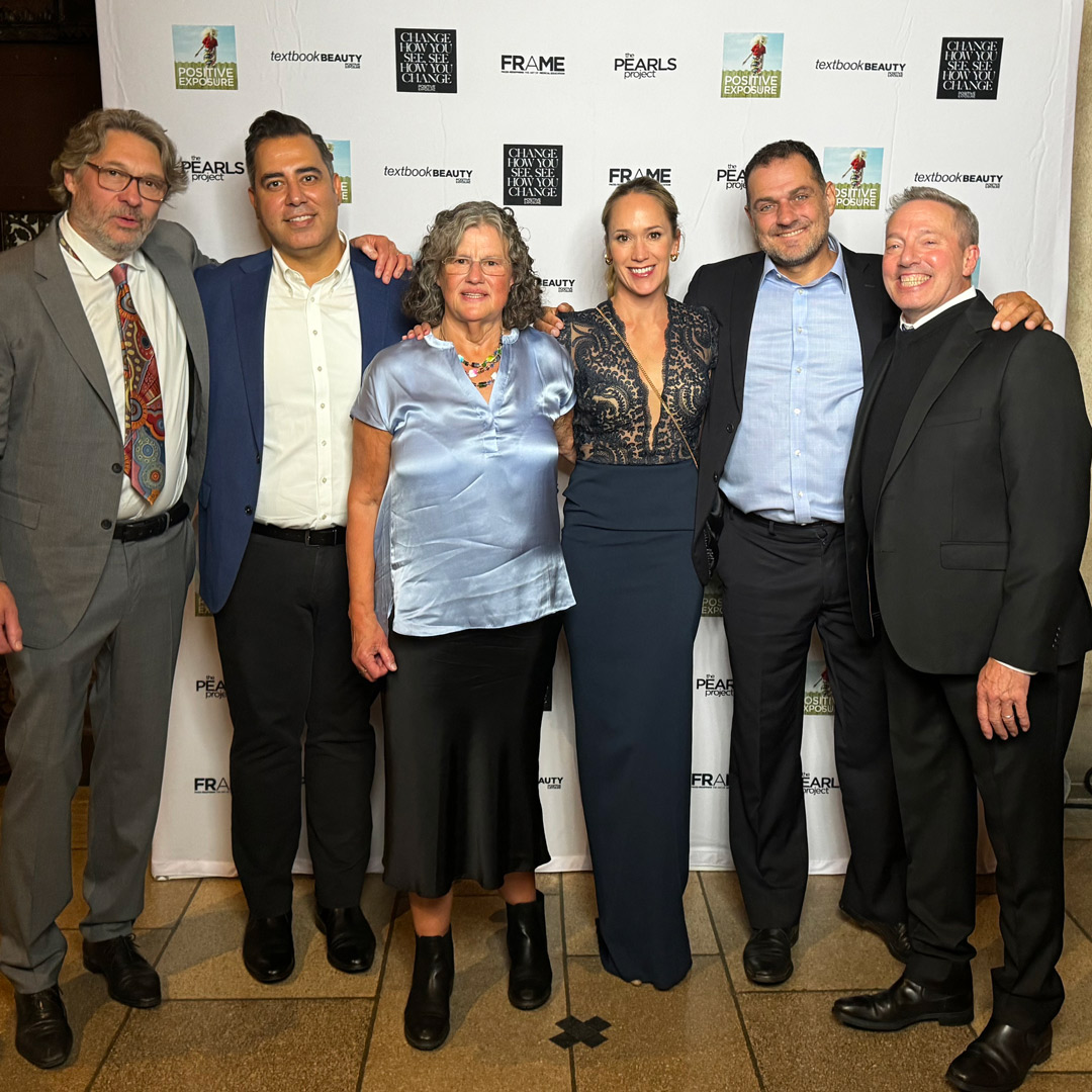 Six people in evening attire, among them Mikk and Helene Cederroth, pose in front of a Positive Exposure gala backdrop.