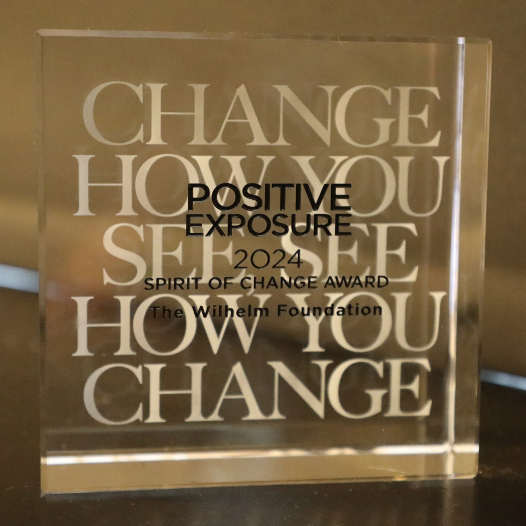 Engraved glass trophy reading Positive Exposure 2024 Spirit of Change Award, The Wilhelm Foundation.
