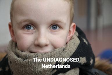 Närbild på en pojke med blå ögon och en stor stjärnmönstrad halsduk, med texten The UNDIAGNOSED Netherlands.