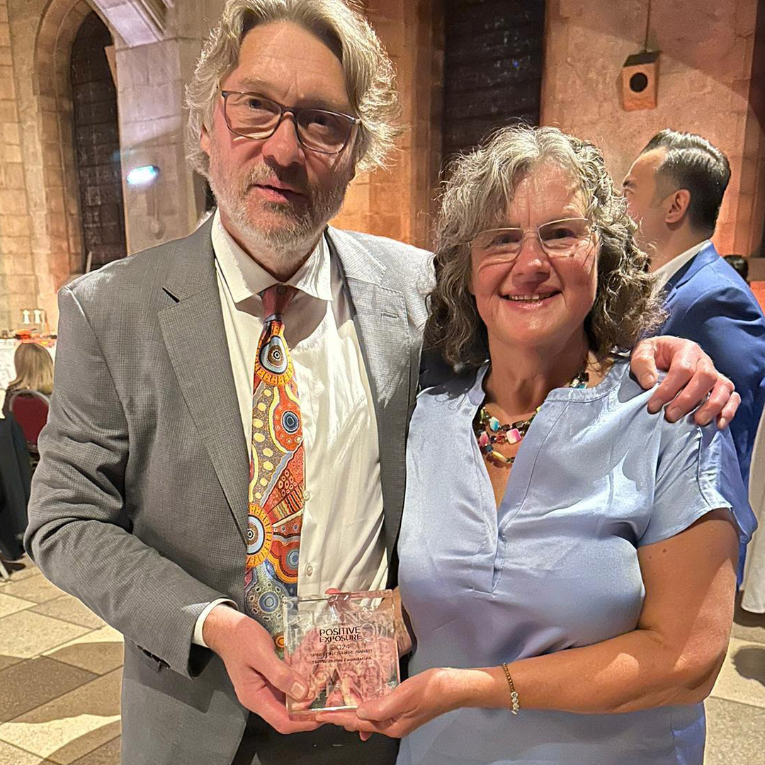 Mikk and Helene Cederroth stand side by side holding the engraved glass Spirit of Change Award.