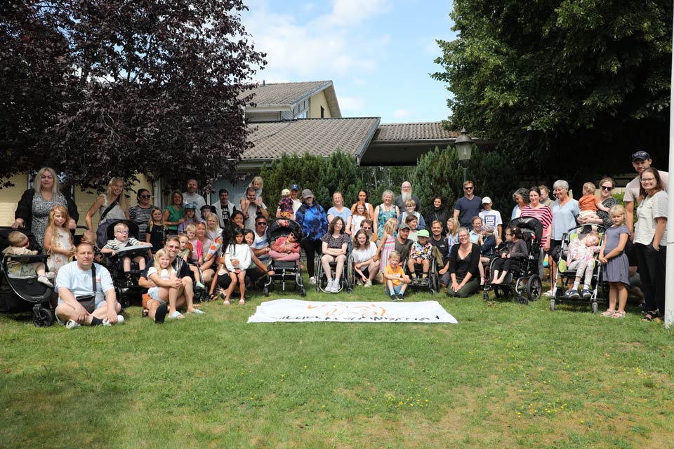 A group of families where some of the children are sitting in wheel chairs.