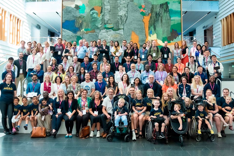 Group photo with 100 adults and in front children and their families wearing blue T-shirt "I know a Hero".