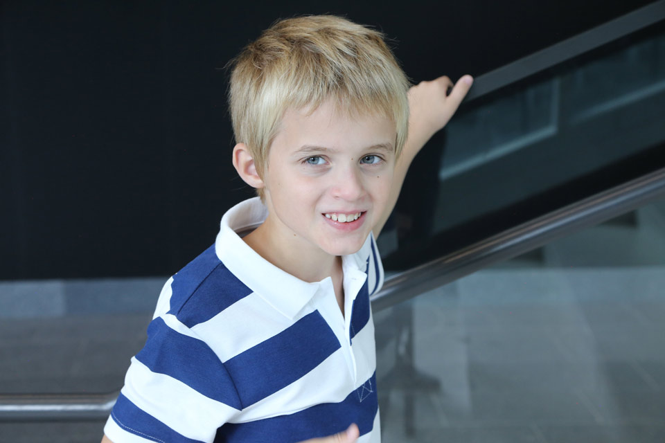 Happy boy walking up a stairway and looking straight at the camera