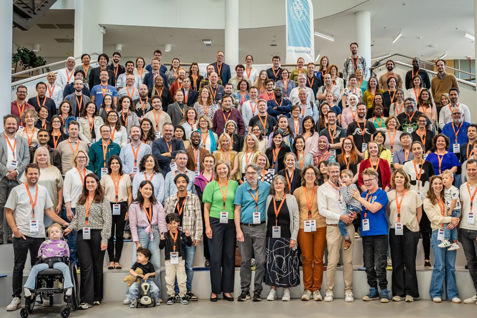 Group photo where approximately 150 adults are standing on a large staircase. At the front, there are adults and a few children.