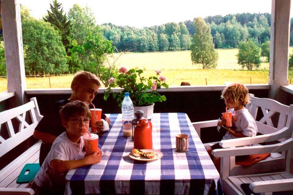 three children sitting on a porch