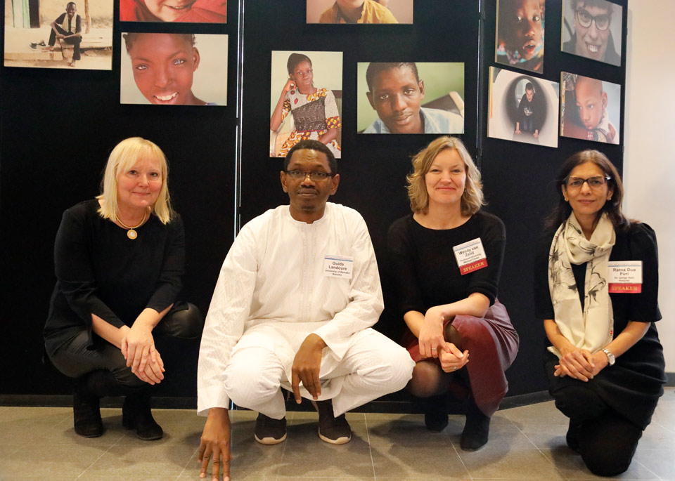 Four people sitting in front of a photo exhibition